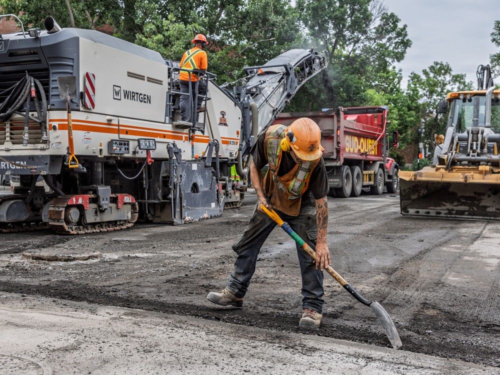 a road crew works on paving a street.