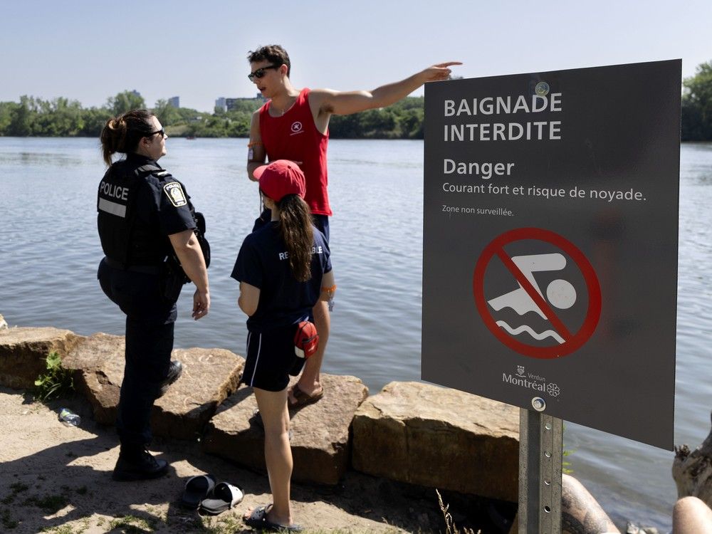 police visit a beach and speak to lifeguards.