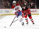 Kirby Duch of the Montreal Canadiens and Cody Glass of the New Jersey Devils compete for the puck during the third period at the Prudential Center on November 6, 2025 in Newark, New Jersey.