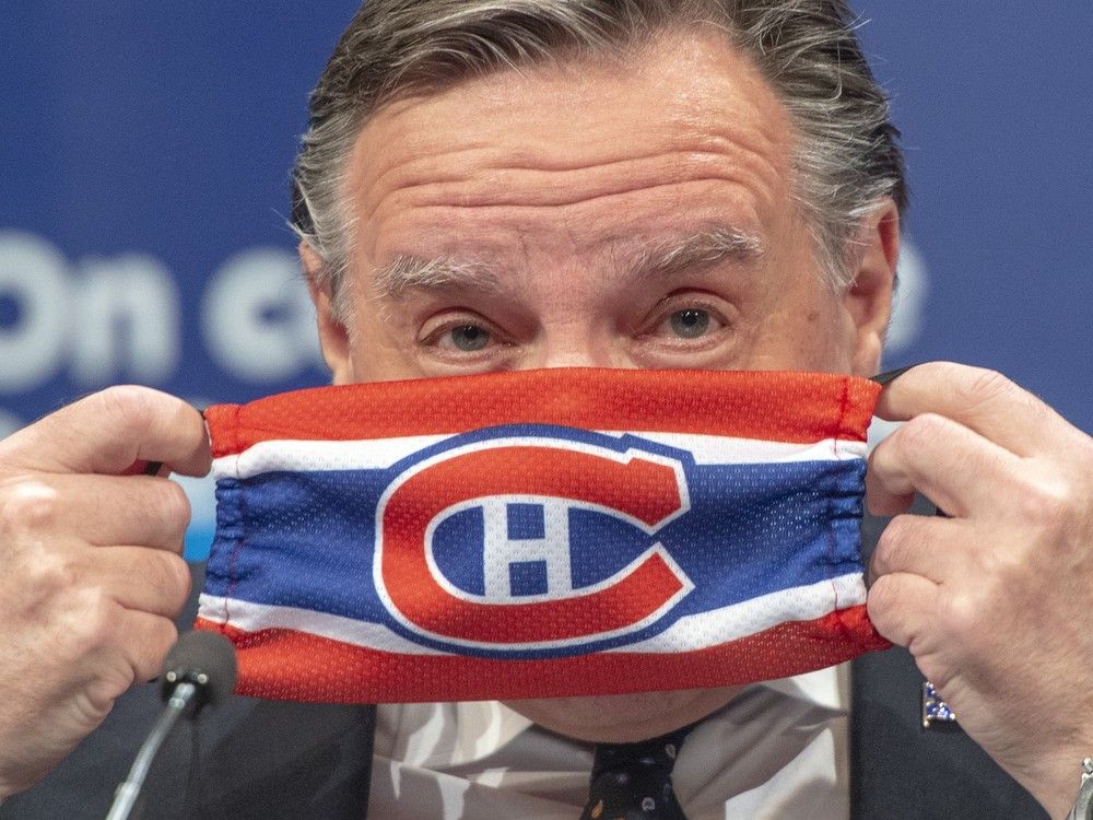  Quebec Premier François Legault puts on a Montreal Canadiens face mask as he finishes a daily COVID-19 press briefing in 2020.