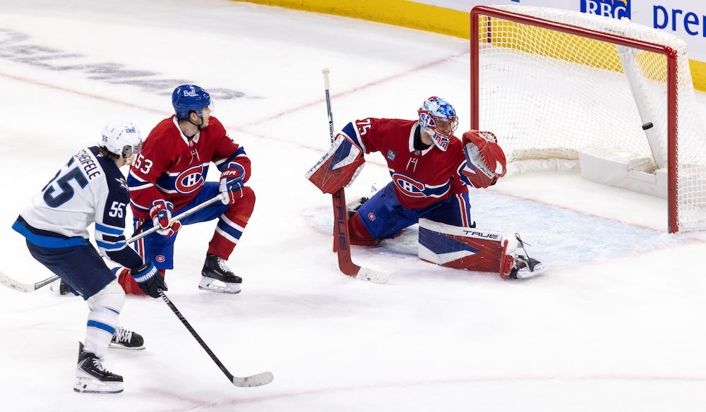  The Winnipeg Jets’ Mark Scheifele shoots the puck past Canadiens defenceman Noah Dobson and goalie Jakub Dobes for the game’s first goal.