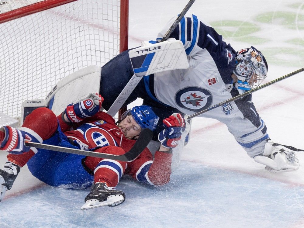  Montreal Canadiens’ Josh Anderson crashes into Winnipeg Jets goalie Eric Comrie during the first period.