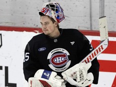 Goalie has his mask flipped up on his head during practice.