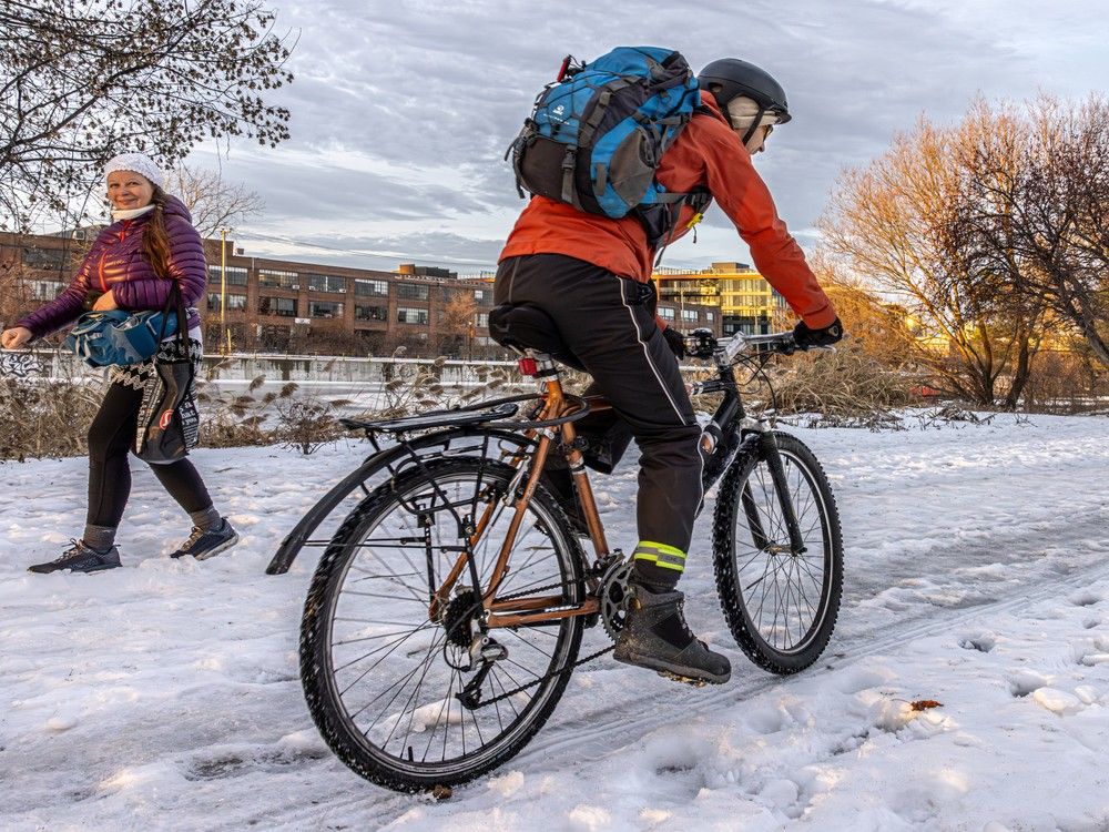 pedestrians and cyclists alike use the bike path west of atwater market in montreal.
