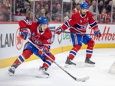 Canadiens' Lane Hutson controls the puck behind his net while being watched by teammate Nick Suzuki during game at the Bell Centre this week.