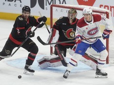 Canadiens centre Jake Evans parks in front of Ottawa Senators goaltender Leevi Merilainen as Artem Zub defends during first period in Ottawa, on Saturday.