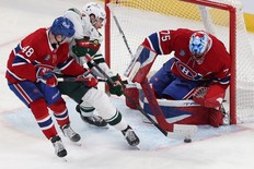 Canadiens goaltender Jakub Dobes shuts the door on Minnesota Wild's Yakov Trenin as Lane Hutson defends during third period in Montreal on Tuesday.