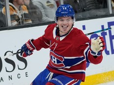 Hockey player grins in celebration after scoring a goal.