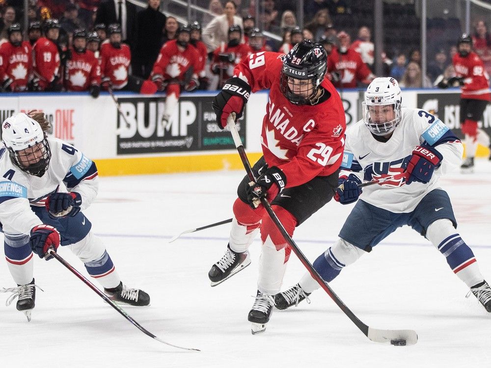  Caroline Harvey, left, and Cayla Barnes defend against Canada’s Marie-Philip Poulin during first period of Rivalry Series game in Edmonton on Dec. 10.