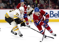 Montreal Canadiens right wing Cole Caufield gets around Boston Bruins centre Elias Lindholm.