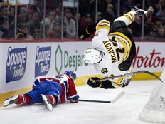 Boston Bruins defenceman Charlie McAvoy is sent flying after being hit by Canadiens blue-liner Noah Dobson during first period in Montreal on Tuesday.