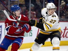 Canadiens winger Cole Caufield keeps a glove up to protect his face from stick of Boston Bruins defenceman Hampus Lindholm during first period in Montreal on Tuesday.