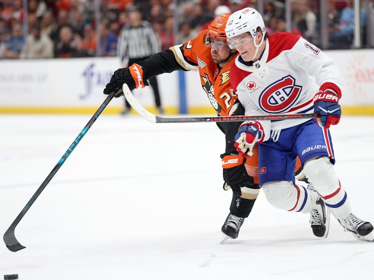  Anaheim Ducks’ Ryan Poehling (25) battles Canadiens’ Cole Caufield (13) for a loose puck during overtime at the Honda Center on Friday, March 6, 2026, in Anaheim, Calif.