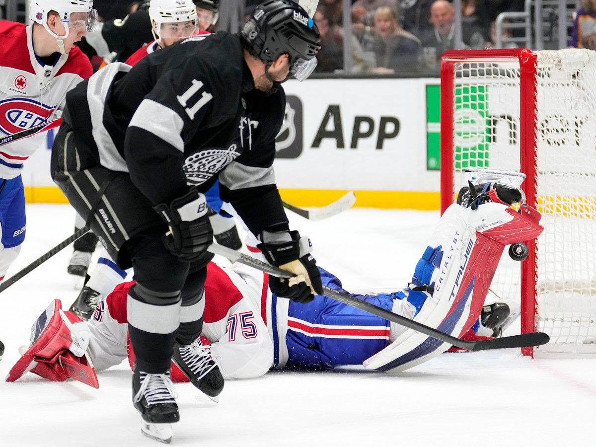 Hockey goaltender flops on the ice to stop a shot.