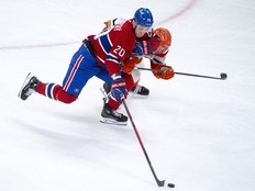 Montreal Canadiens' Juraj Slafkovsky battles Anaheim Ducks' Jackson LaCombe for the puck.