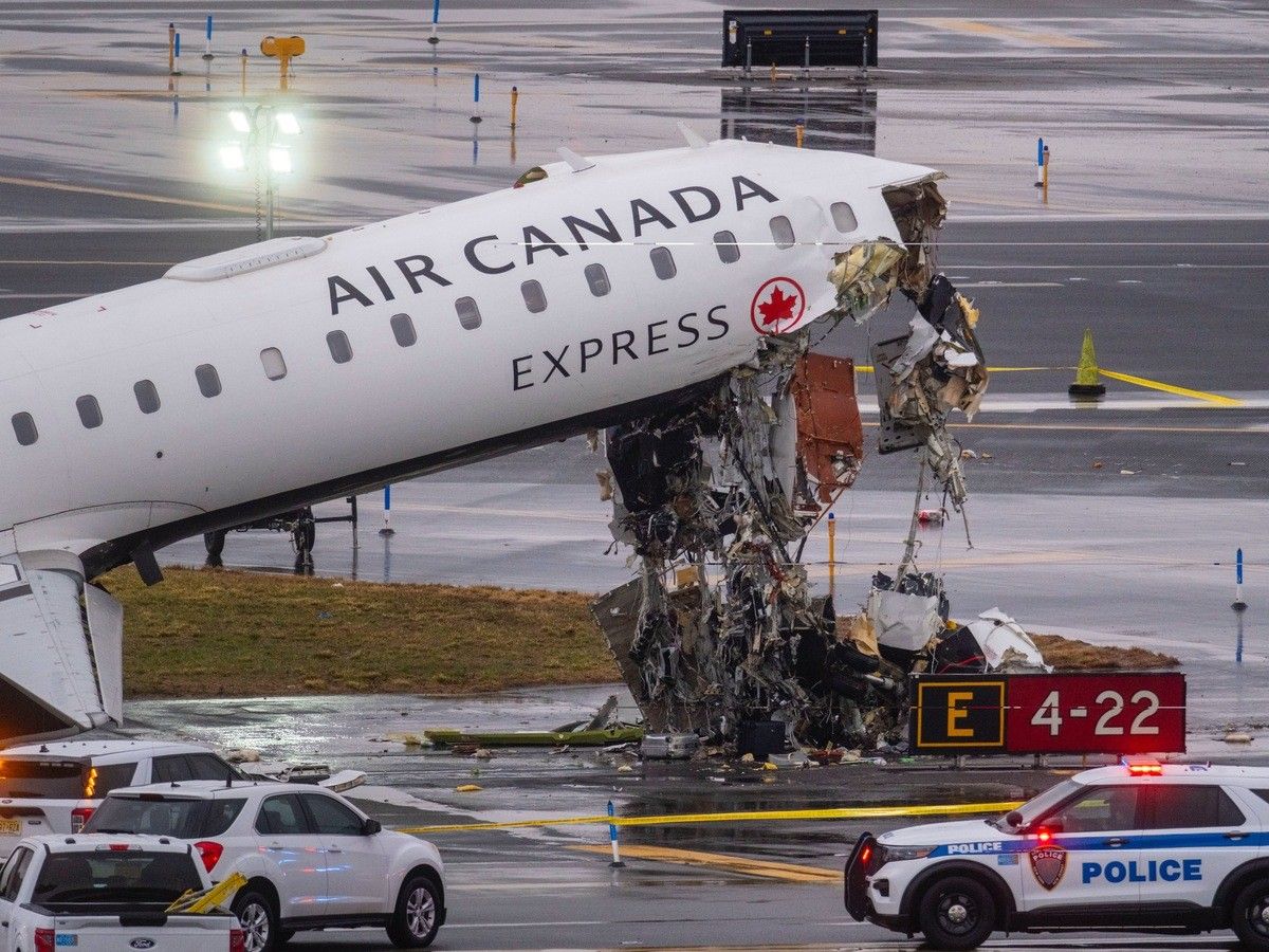 An Air Canada plane's nose is high off the ground and ripped to shreds near an airport runway