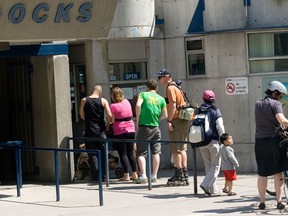 People wait in line at the Toronto Island Ferry Docks
