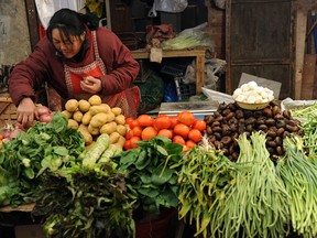A vendor sells vegetables at a market