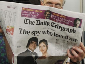 A passenger reads the Daily Telegraph newspaper, featuring a front page interview with the ex-husband of accused Russian spy Anna Chapman.