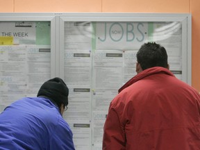 Job seekers look over a list of jobs at an employment center in San Francisco.