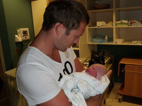 Australian Sebastian Terry holds newborn Oakley Gregory Verne Sanguin on Saturday, Aug. 28 in Regina.