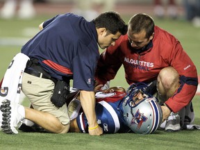 Montreal Alouettes medical personnel tend to quarterback Anthony Calvillo after he was injured during the second quarter of action against the Winnipeg Blue Bombers during Canadian Football League game in Montreal, August 19, 2010.