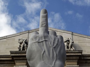 A sculpture by Italian contemporary artist Maurizio Cattelan is seen on display in front of the Milan Stock Exchange.