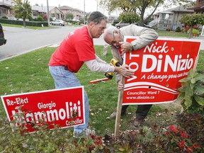 Election campaign workers for Nick Di Nizio in Ward 7, Santino Tinaburri (RIGHT) and Peter Broersma (LEFT) place signs on a lawn near Sheppherd Avenue and Weston Road in Toronto, Wednesday October 20, 2010