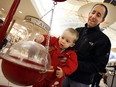 In a file photo, Zach Ublansky, with his father, David, unofficially kicks off the Salvation Army's annual Christmas Kettle Campaign in 2005.