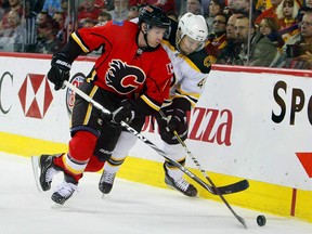 Dennis Seidenberg of the Boston Bruins battles for the puck against Brendan Morrison of the Calgary Flames during their NHL game at Scotiabank Saddledome, February 22, 2011 in Calgary, Alberta, Canada.