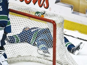 Vancouver Canucks Dan Hamhuis lies behind the net after he was knocked hard into the boards by Anaheim Ducks Ryan Getzlaf during the third period of their NHL hockey game in Vancouver, February 9, 2011.