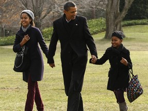 U.S. President Barack Obama holds hands with daughters Malia (L) and Sasha as first lady Michelle Obama walks behind upon their return to the White House in Washington January 4, 2010, following their vacation in Hawaii.
