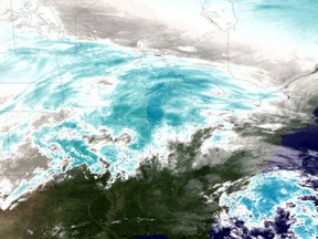 East satellite image from the National Oceanic and Atmosphere Administration (NOAA), a water vapor image shows areas of high atmospheric moisture, colored in shades of blue, of a winter storm as it moves across the midwest area of the U.S. More than 20 states are currently under storm warnings or advisories from the National Weather Service.
