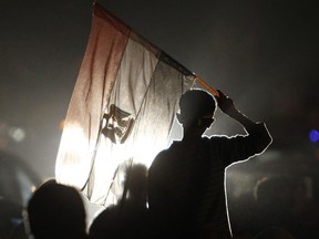 An Egyptian protester waves an Egyptian flag at Tahrir Square.