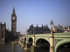 Pedestrians walk across Westminster Bridge in front of the Big Ben Clock Tower, in London March 8, 2011.