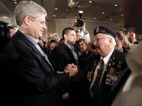 Conservative leader and Canada's Prime Minister Stephen Harper greets a veteran after unveiling his party's platform during a campaign event in Mississauga.