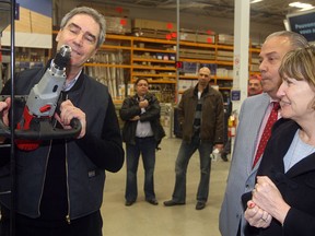 Liberal leader Michael Ignatieff checks out some of the hardware, tools and gadgets during a tour stop at a Rona store in Gatineau Thursday, where he spoke to reporters and delivered part of his platform. Here, he checks out some power tools as his wife Zsuzsanna Zsohar looks on.
