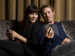 “I just got a message saying that we should be having that photo shoot any second now.” Carly Pope, left, and Jason Lewis are tech-obsessed in Textuality.