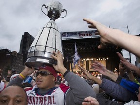 Montreal Alouettes' John Bowman carries the Grey Cup into the crowd during the team's victory parade in Montreal December 1, 2010.