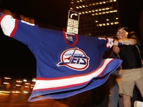 A hockey fans cheers at the corner of Portage and Main in downtown Winnipeg after media reports of the Atlanta Thrashers hockey team moving to Winnipeg, May 19, 2011.