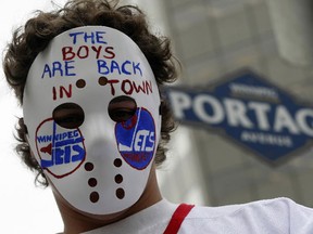 Kristian Rents celebrates Winnipeg's return to the NHL by donning a hockey mask with message.