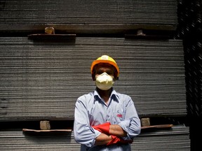 D.K Upadhya poses for a photograph wearing safety clothes at the Everest Industries Ltd. in Lakhmapur, India, on Wednesday, May 18, 2011. Photographer: Adeel Halim/Bloomberg