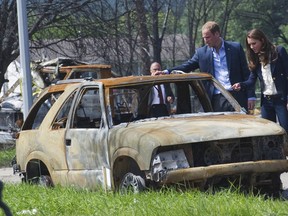 Britain's Prince William and his wife Catherine, the Duchess of Cambridge look at the damage left after a forest fire in Slave Lake, Alberta July 6, 2011. The Royal couple made a side trip to visit the community that was 30 percent destroyed by the fire earlier this year. The Prince and his wife Catherine are on a royal tour of Canada from June 30 to July 8. REUTERS/Andy Clark    (CANADA - Tags: ROYALS SOCIETY ENTERTAINMENT POLITICS)