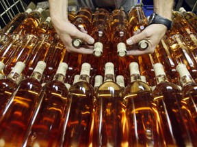 A worker prepares bottles of rose wine at the Domaine Saint Andre de Figuiere at La Londe Les Maures in Provence September 1, 2008. Rose wine seems to be shedding its image as a sweet, unsubstantial summertime tipple if recent sales figures from around the world are anything to go by. Picture taken September 1, 2008. REUTERS/Jean-Paul Pelissier (FRANCE)