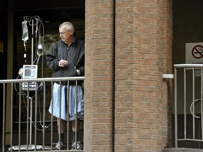 A man has a cigarette outside of St. Michael's Hospital in downtown Toronto Monday afternoon.