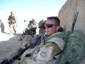 Ryan Flavelle, pictured when he was a master corporal serving in Afghanistan, has written a memoir to explain what the war was like for Canadian soldiers and what they did. The face of the soldier sitting at Flavelle’s right has been blurred to protect the identity of the individual.