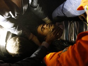 An earthquake survivor is carried out by rescue workers from a collapsed building in Ercis, near the eastern Turkish city of Van, October 24, 2011. Rescuers pulled survivors from beneath mounds of collapsed buildings and searched for the missing on Monday after a major earthquake killed at least 264 people and wounded more than 1,000 in mainly Kurdish southeast Turkey. REUTERS/Caner Ozkan (TURKEY - Tags: DISASTER ENVIRONMENT)