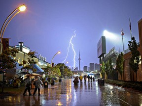 Canadian National Exhibition (CNE) goers run to take cover from the rain as a massive storm hits Toronto, Wednesday evening, August 24, 2011.