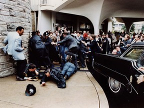 Police and Secret Service agents react moments after former U.S. President Ronald Reagan was shot by John Hinckley Jr. outside the Washington Hilton, Mar. 30, 1981.