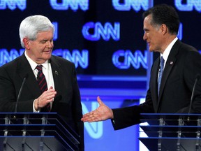 Republican presidential hopeful and former Speaker of the House Newt Gingrich (L) reaches to shake hands with former Massachusetts Governor Mitt Romney after the Republican presidential candidates debate in Jacksonville, Florida January 26, 2012